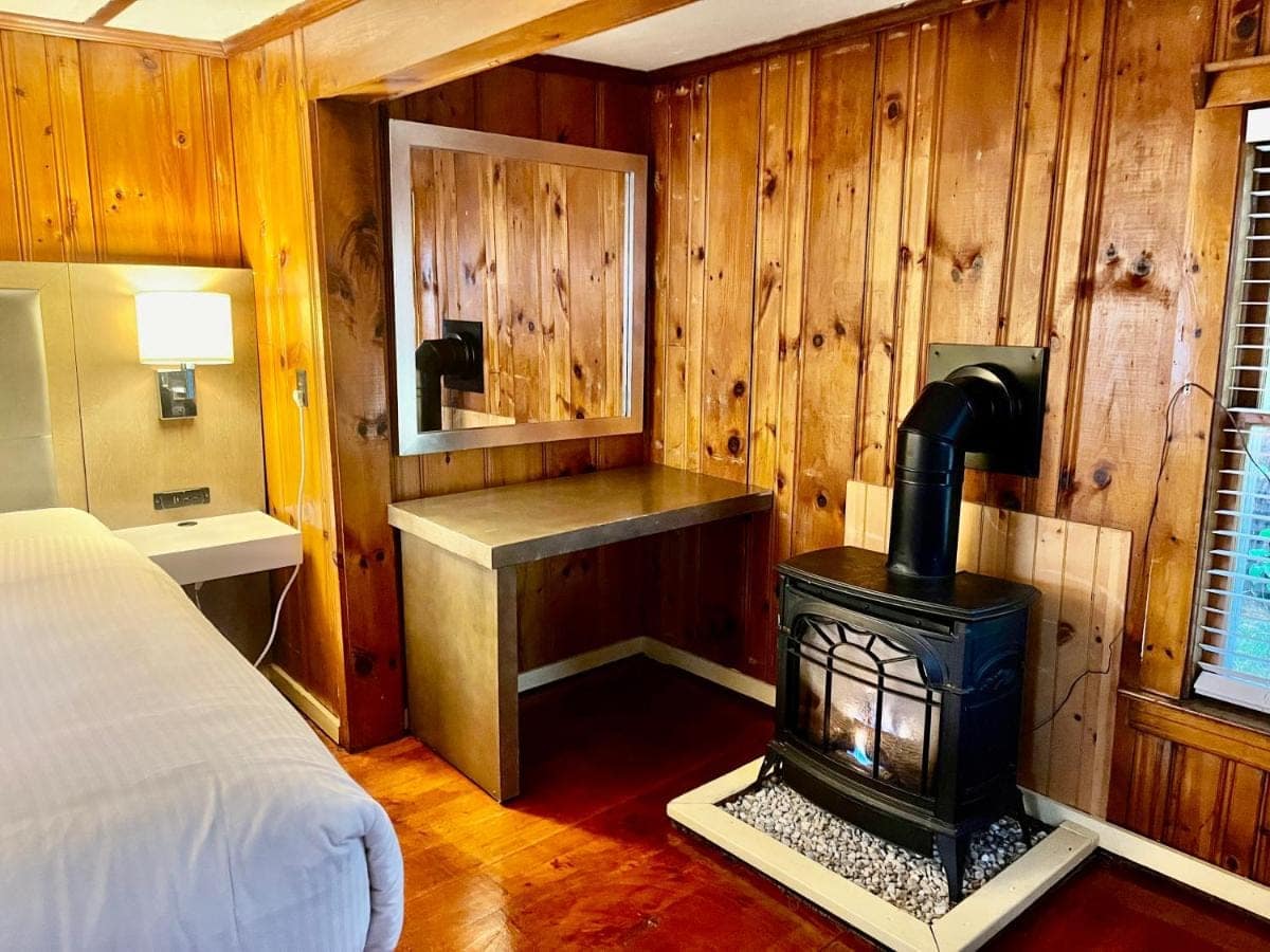 Bedroom with a gas stove, writing desk and pine-panelled walls