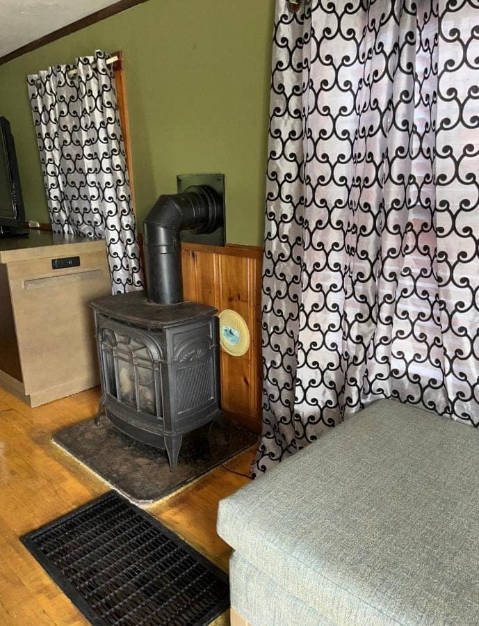 Gas stove and upholstered seating beside a curtained window