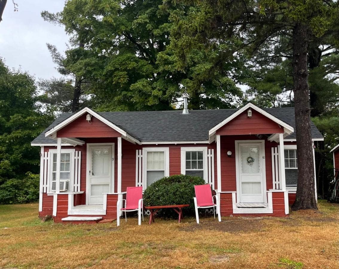 Two red cabins side by side, each with its own covered porch
