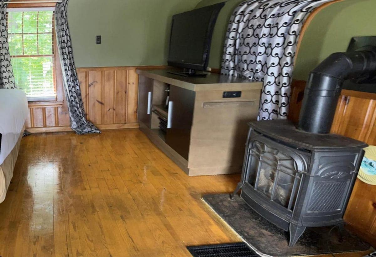 Sitting area with hardwood floors, a TV and a gas stove