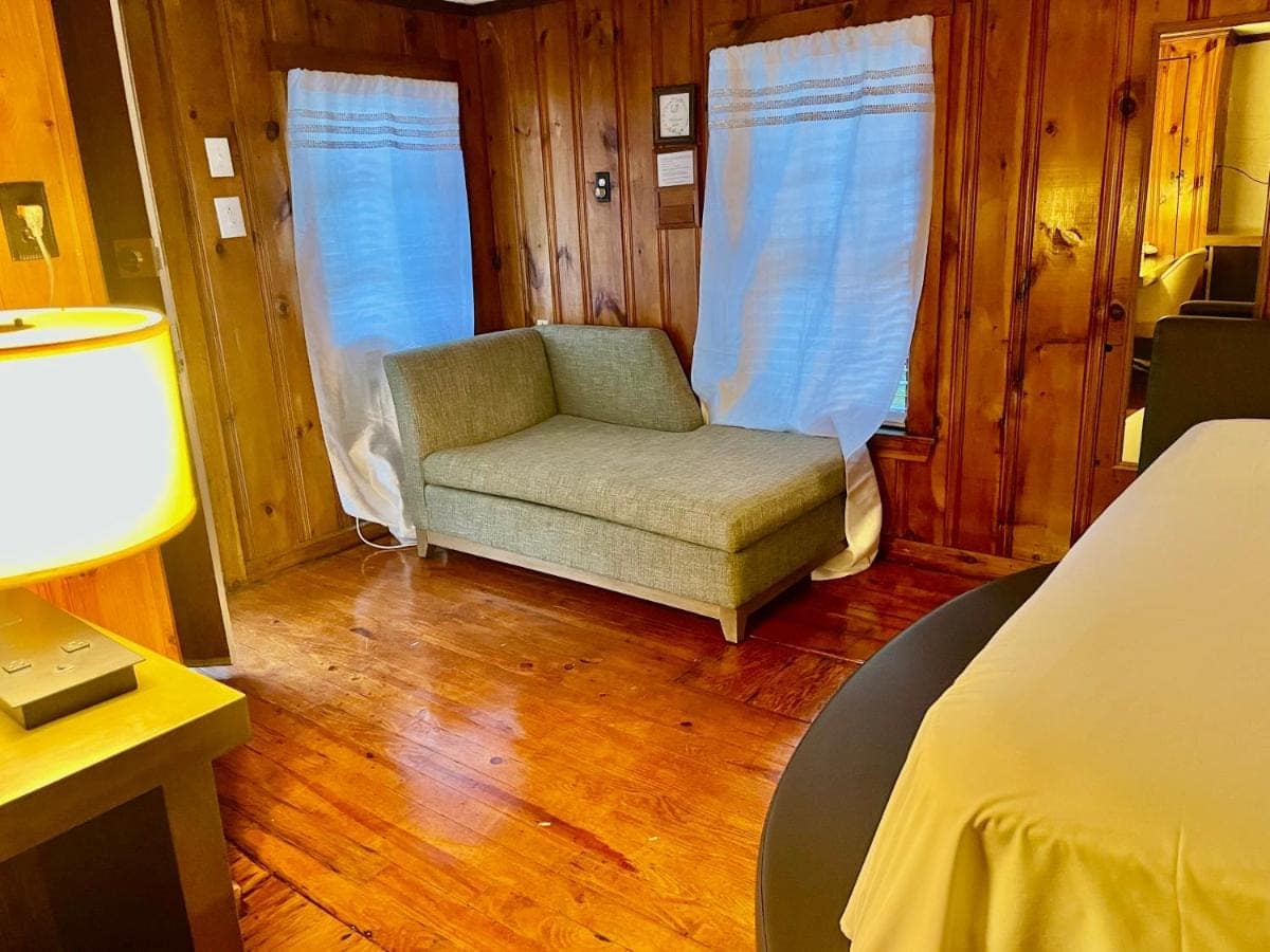 Chaise longue by the windows on wide plank floors